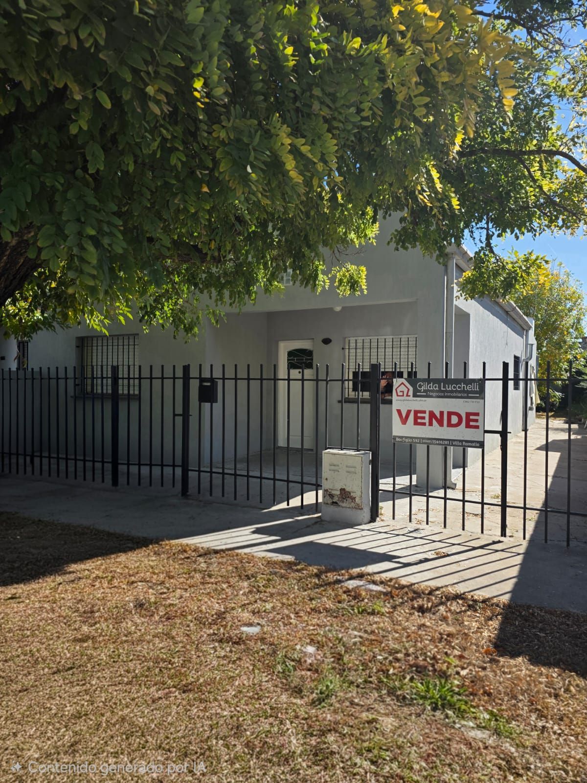 Casa blanca detrás de una verja negra con un cartel rojo de
