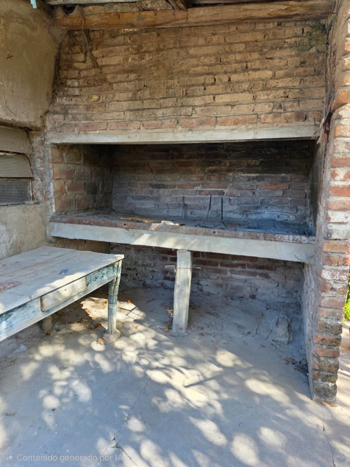 Barbacoa exterior de ladrillo con parrilla integrada y mesa de preparación de hormigón a la luz del sol.