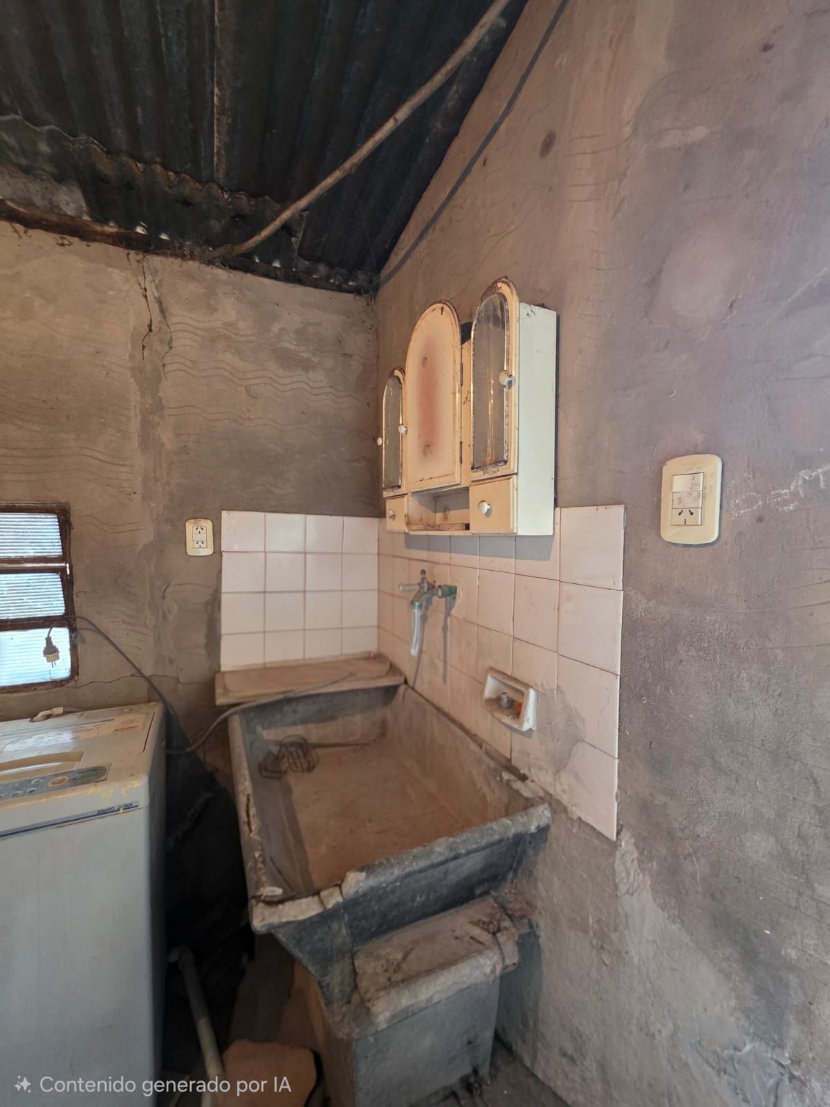 Pequeña cocina rústica con fregadero alicatado, armarios de madera y lavadora en una habitación enlucida.