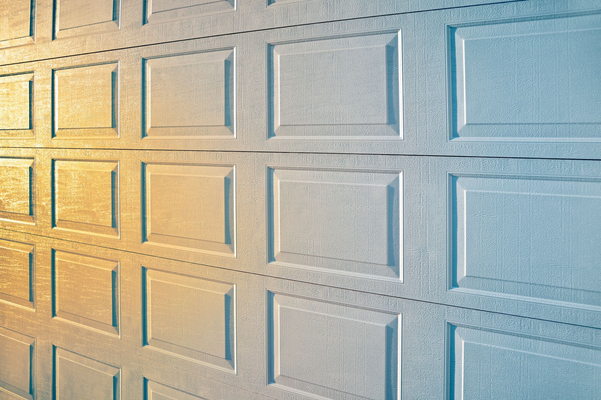 Two-story white house with brick accents, two-car garage, and driveway.