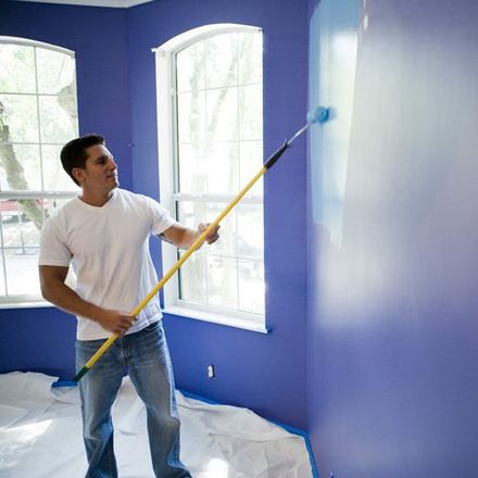 man painting blue wall