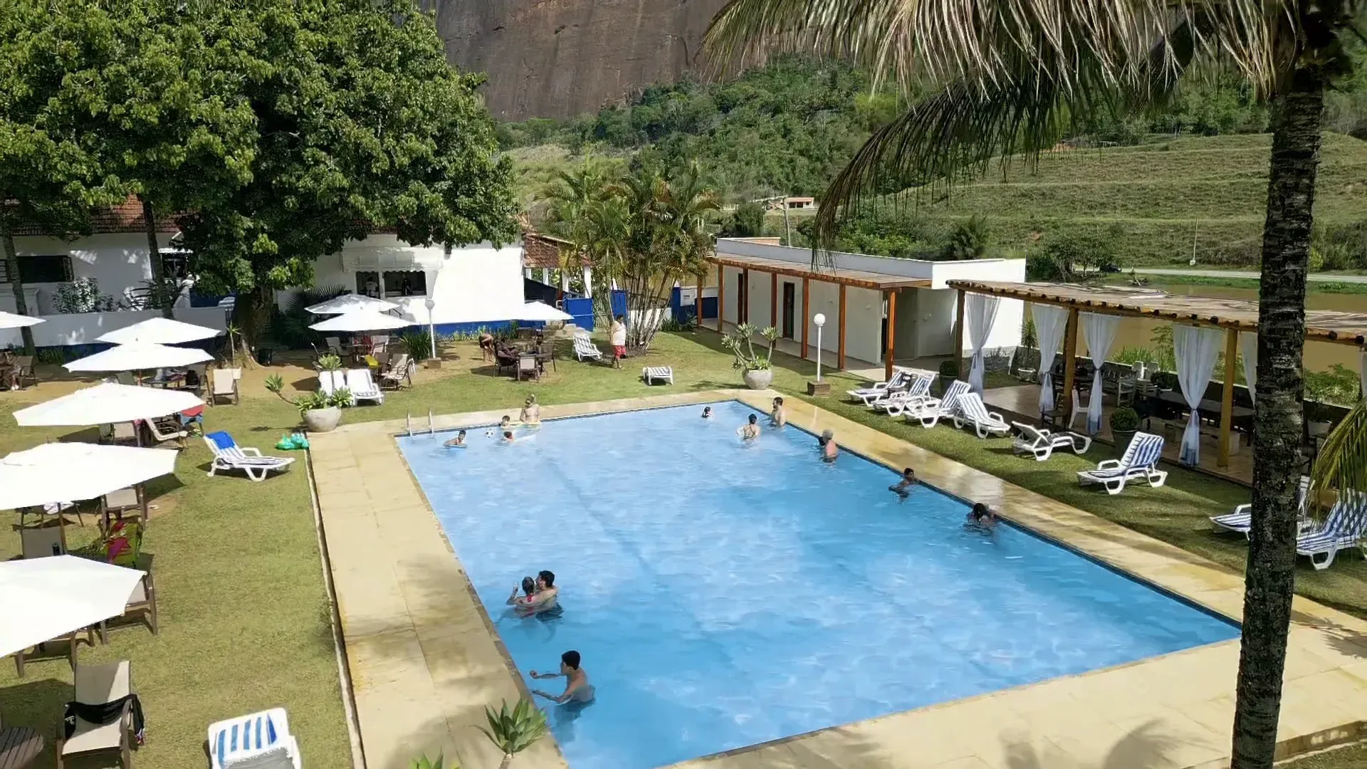 Uma grande piscina cercada por cadeiras e guarda-sóis