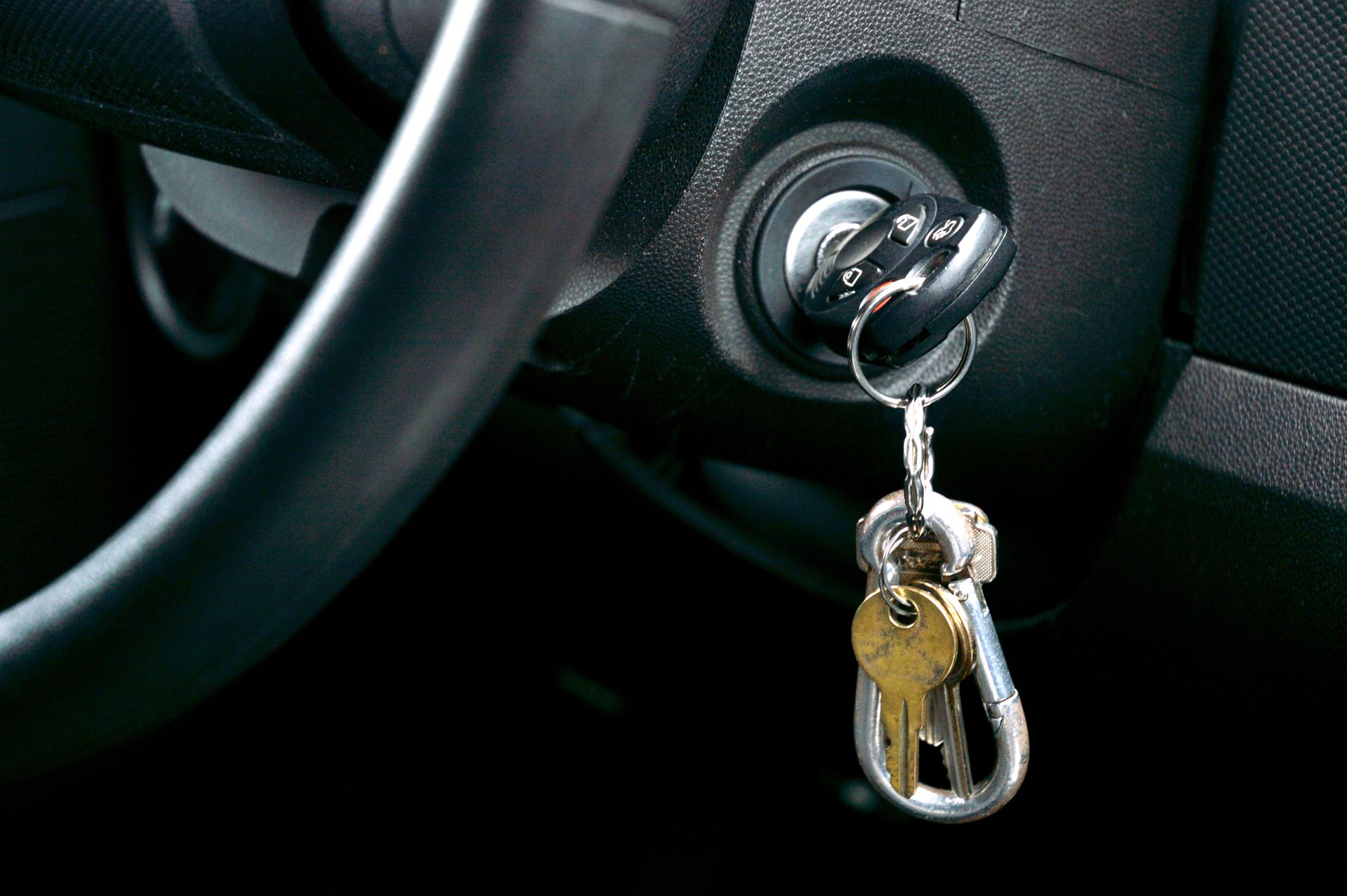 A person checking a car's engine oil with a dipstick. Yellow car hood open, dark skin, engine components visible.
