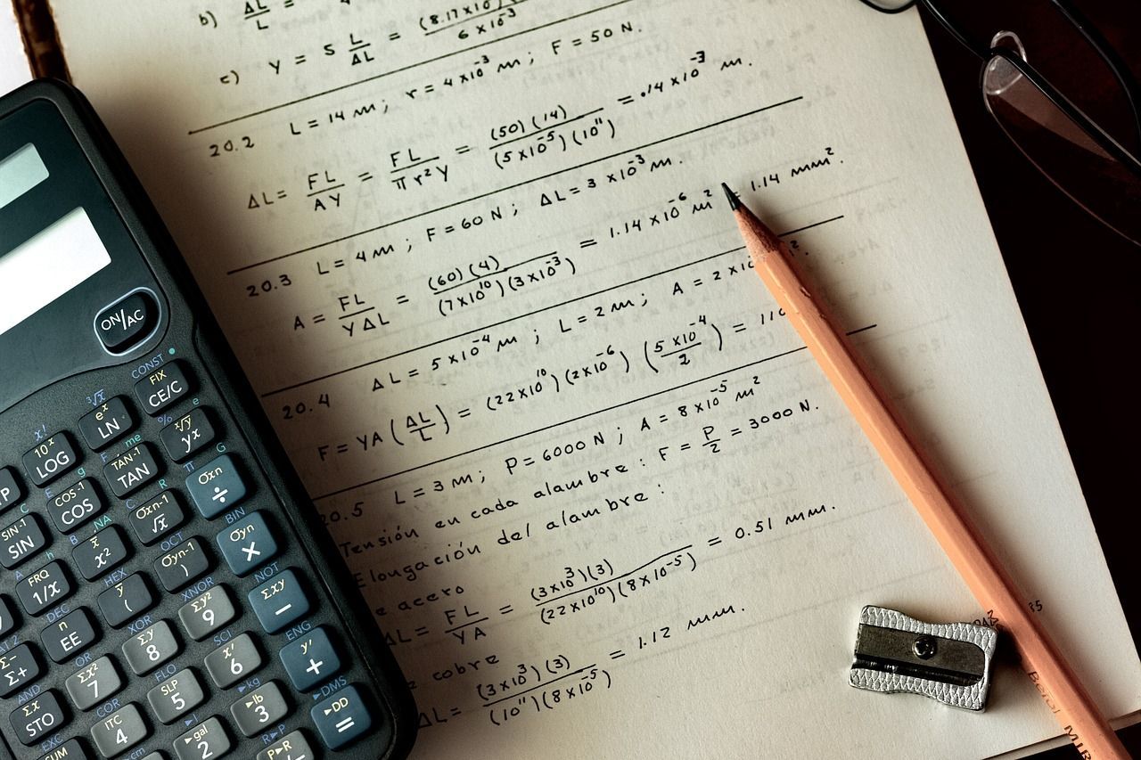 A calculator sits on a piece of paper next to a pencil