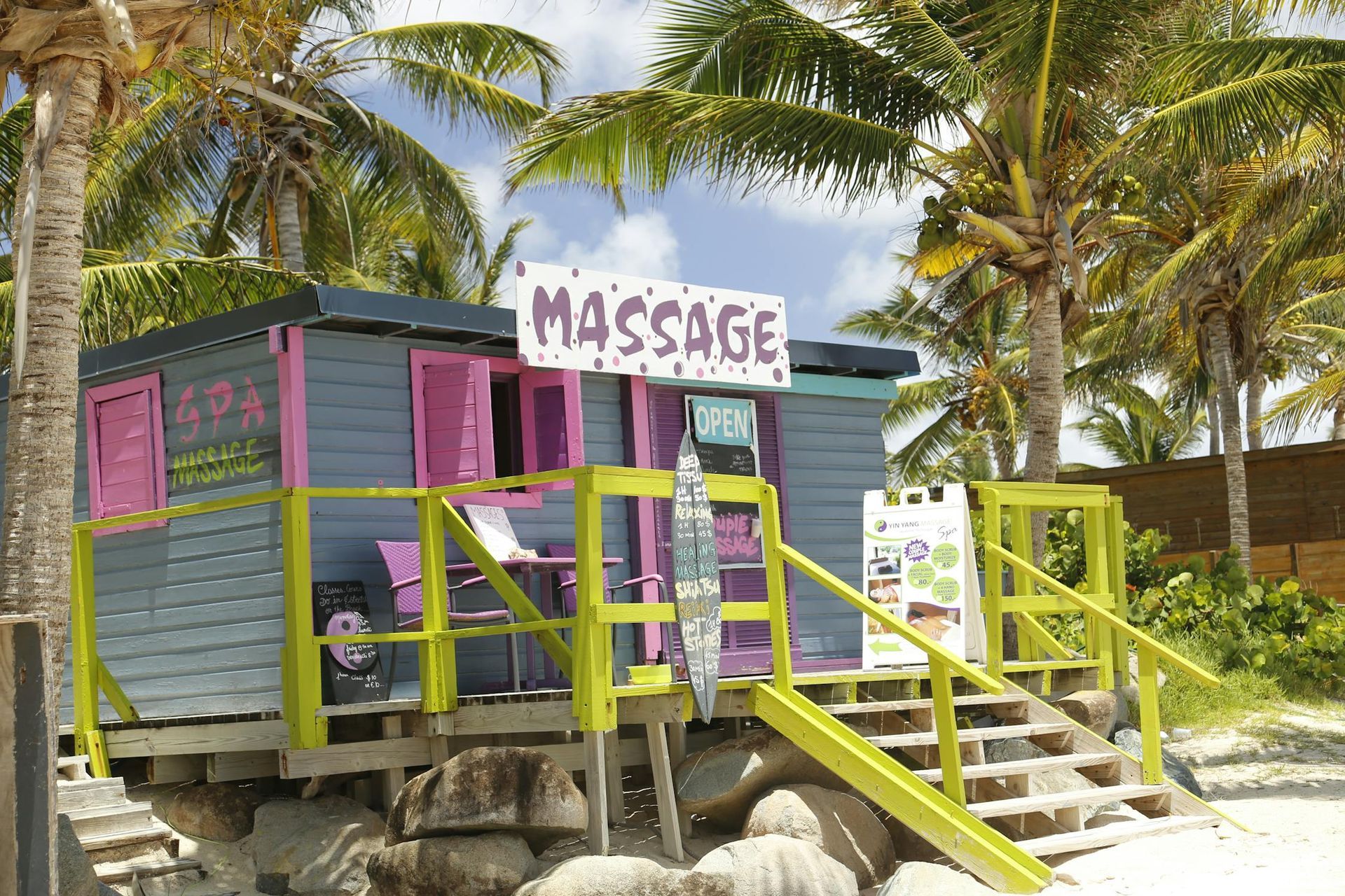 A small pink and purple massage shop on the beach