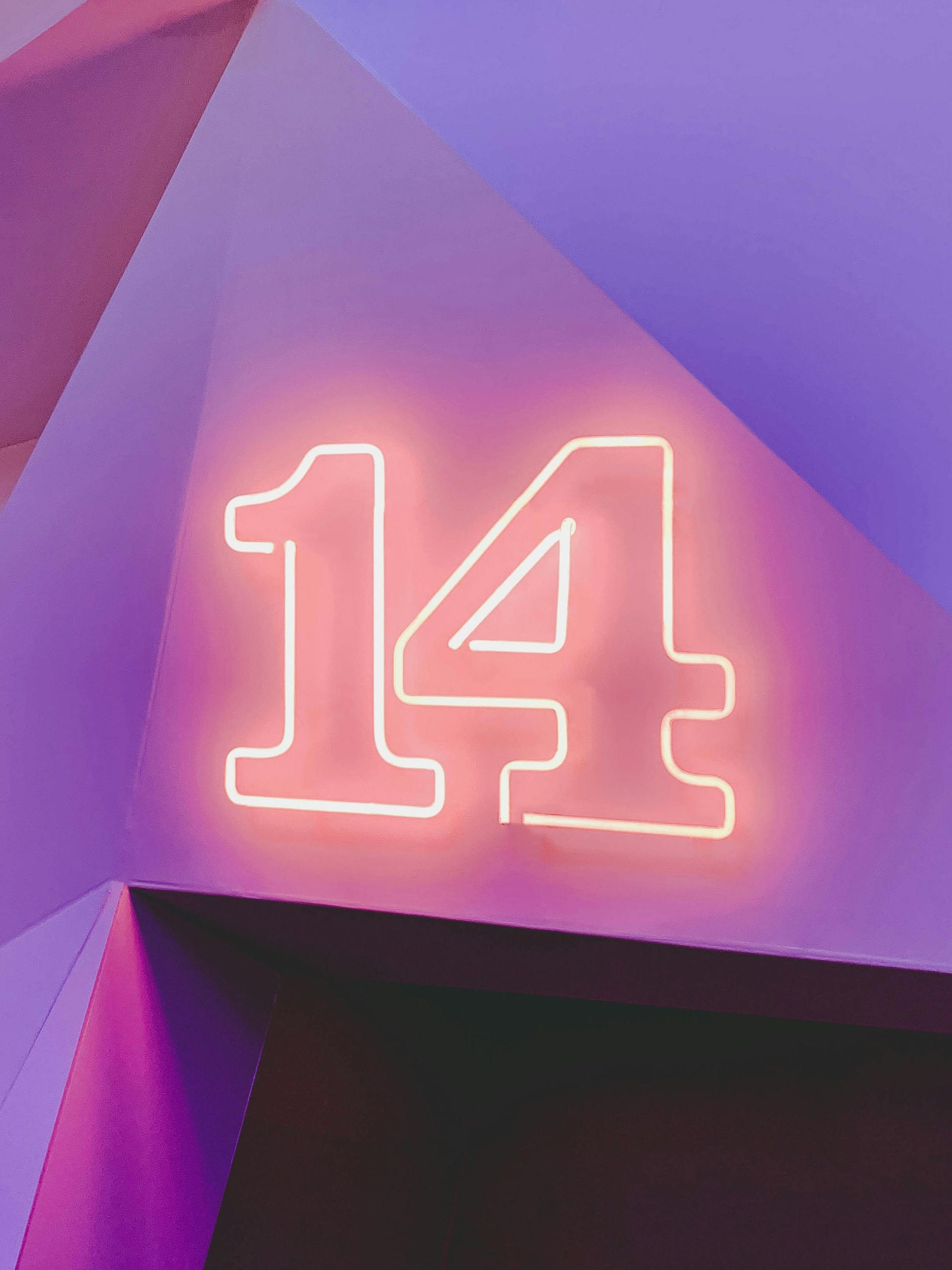 A neon sign with the number 14 on a purple background.