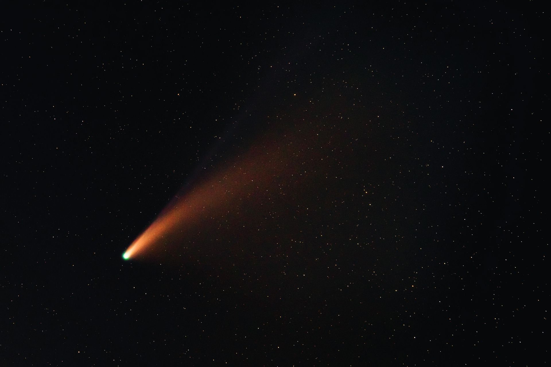 A comet is flying through a starry night sky.