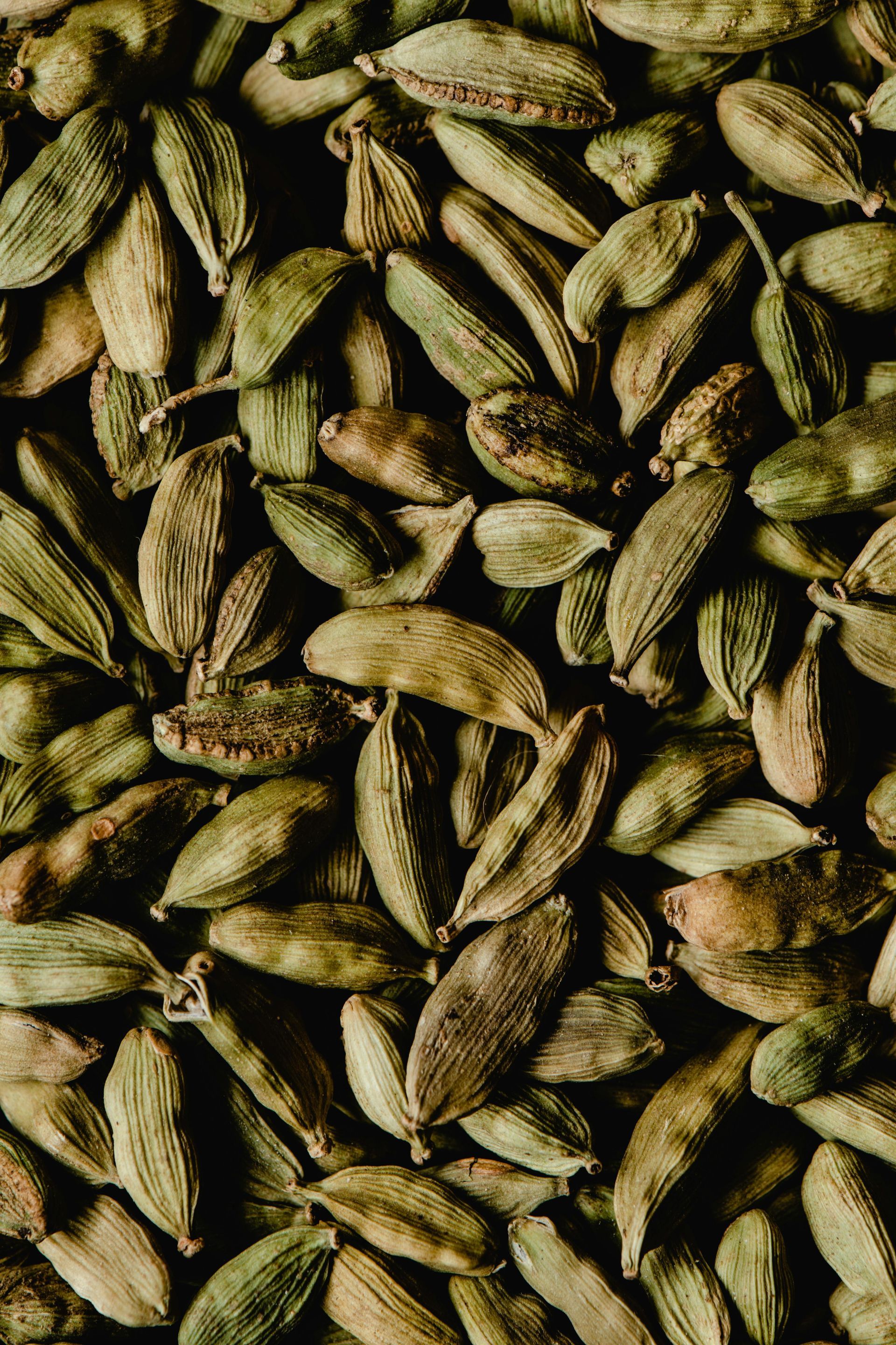 A close up of a pile of cardamom seeds on a table.