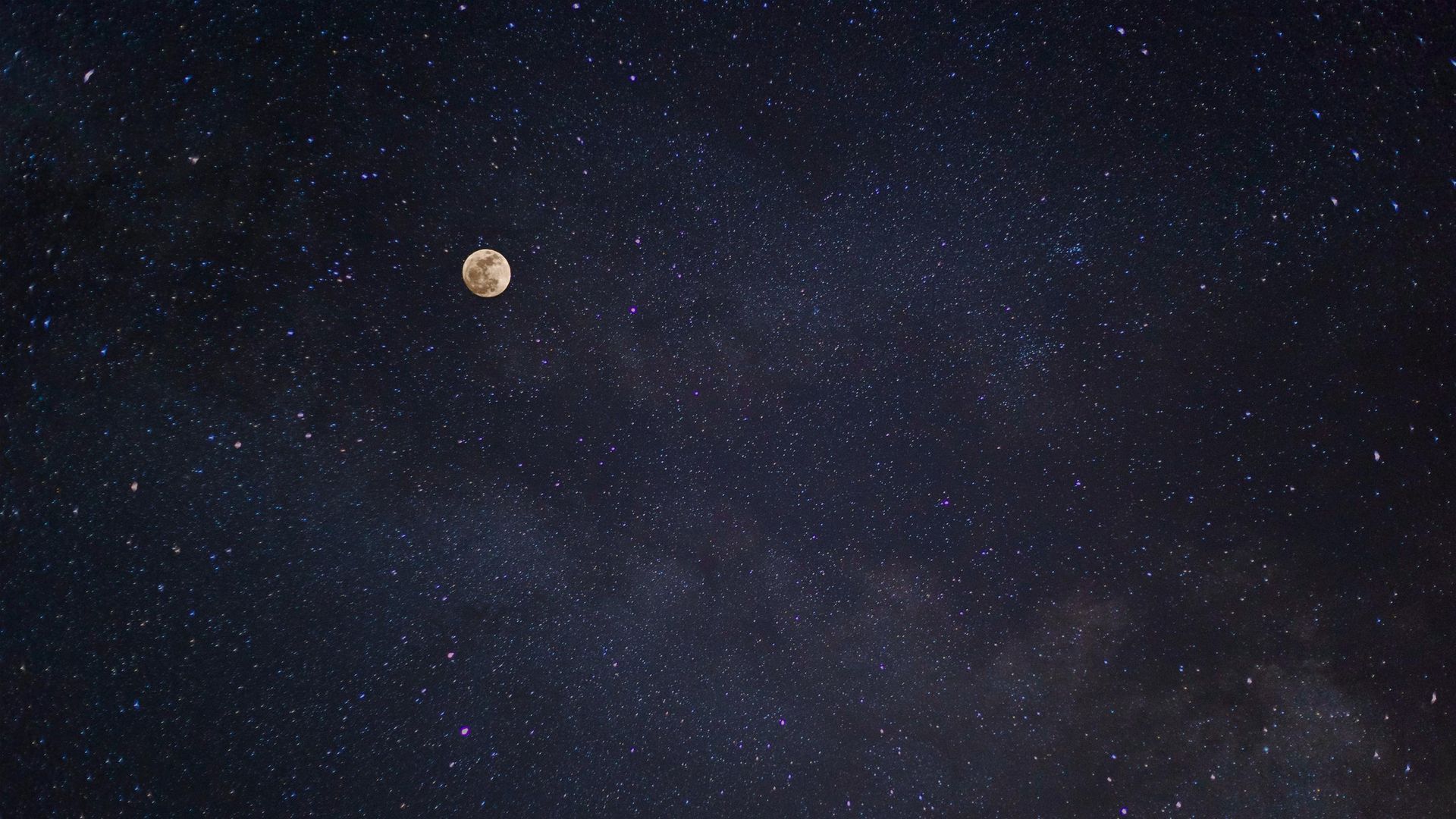The moon is visible in the night sky surrounded by stars.