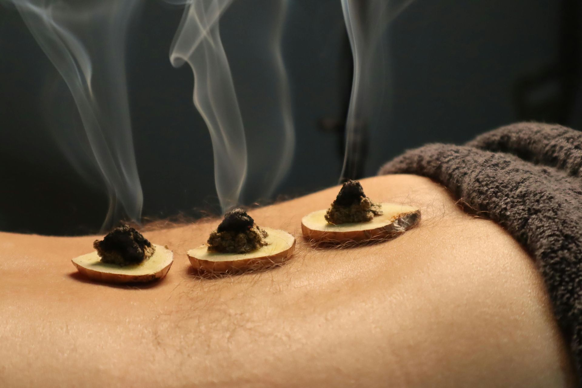 A person is getting a massage with smoke coming out of their back.