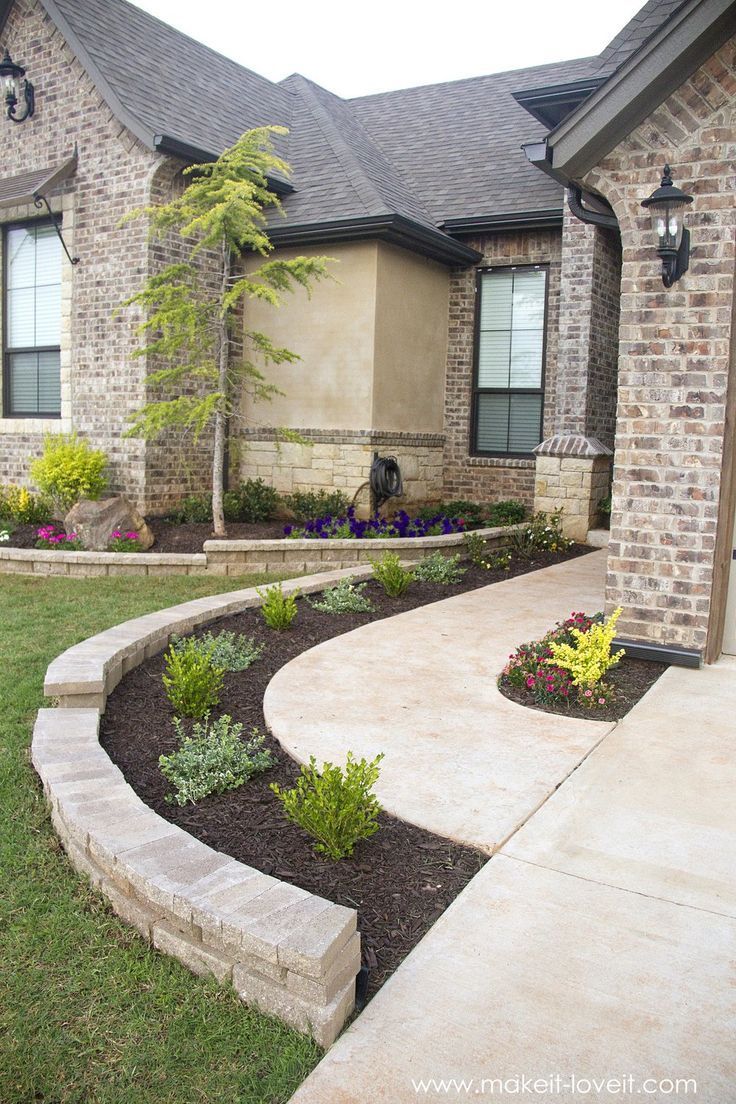 A brick house with a curved walkway leading to it.