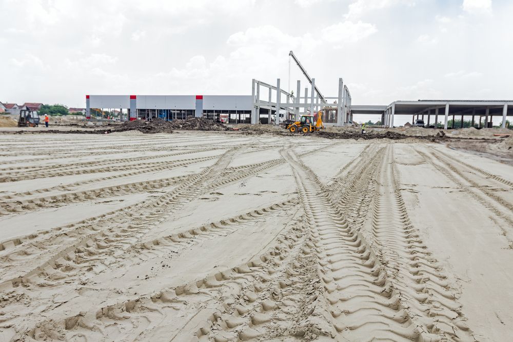 A Large Building Is Being Built On A Dirt Field — Dubbo Hardcore Soils & Earthmoving In Dubbo, NSW