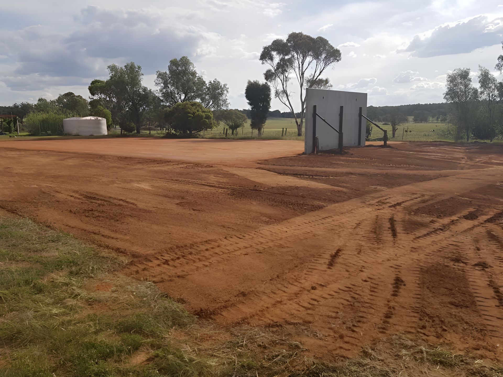 A Dirt Field With A Fence And Trees In The Background — Dubbo Hardcore Soils & Earthmoving In Dubbo, NSW