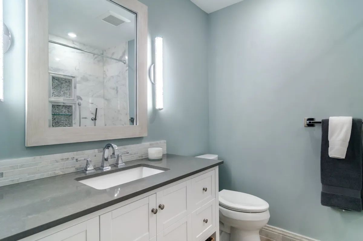 A bathroom with a sink , toilet and mirror.