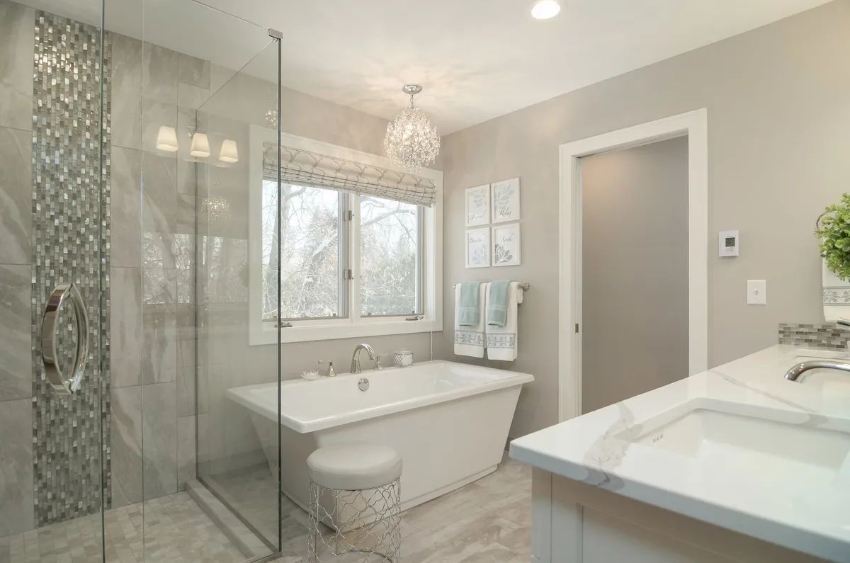 A bathroom with a tub , sink , and walk in shower.