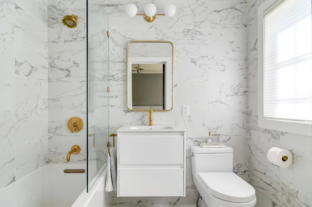A bathroom with a toilet , sink , and shower.