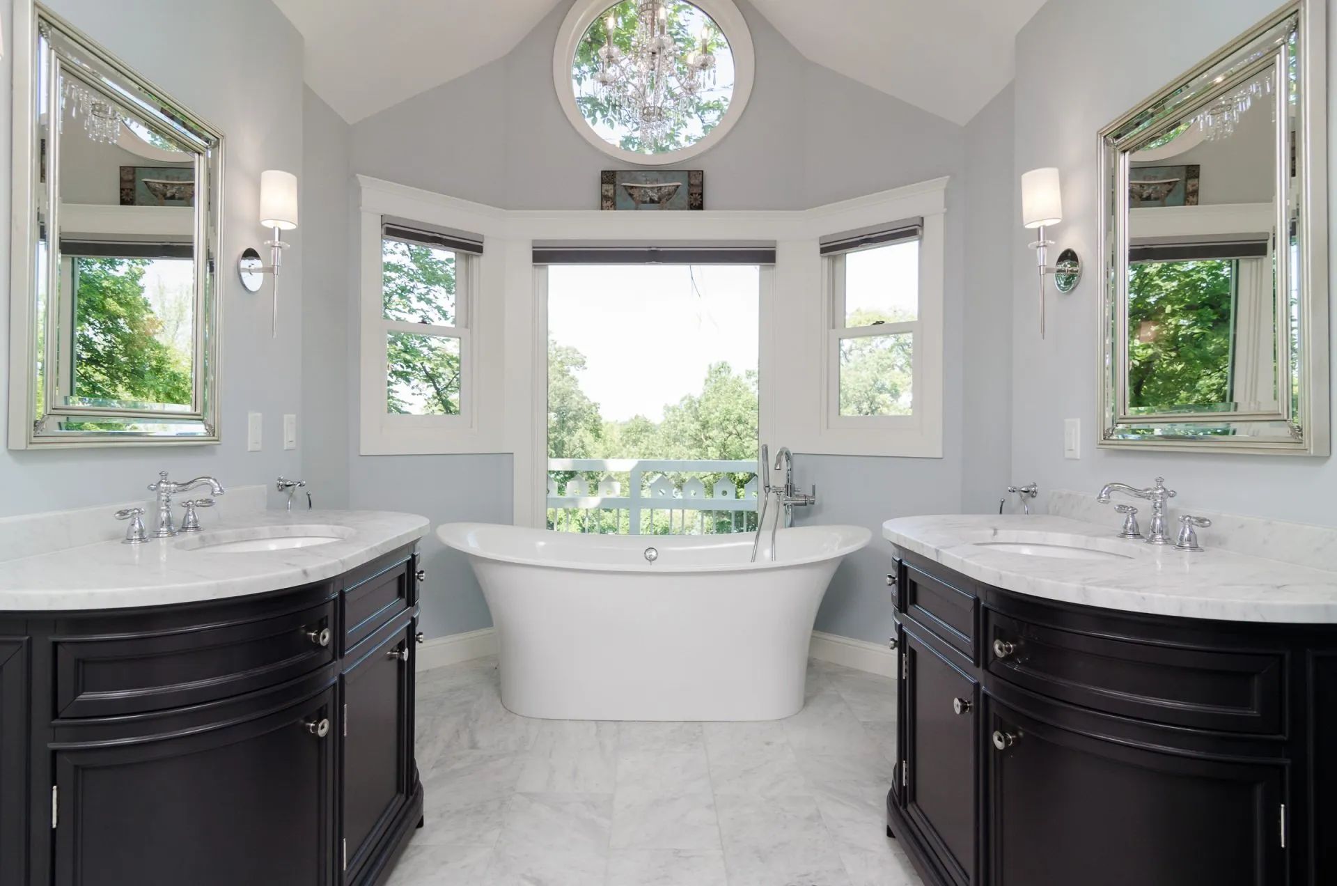 A bathroom with two sinks , a tub and a window.