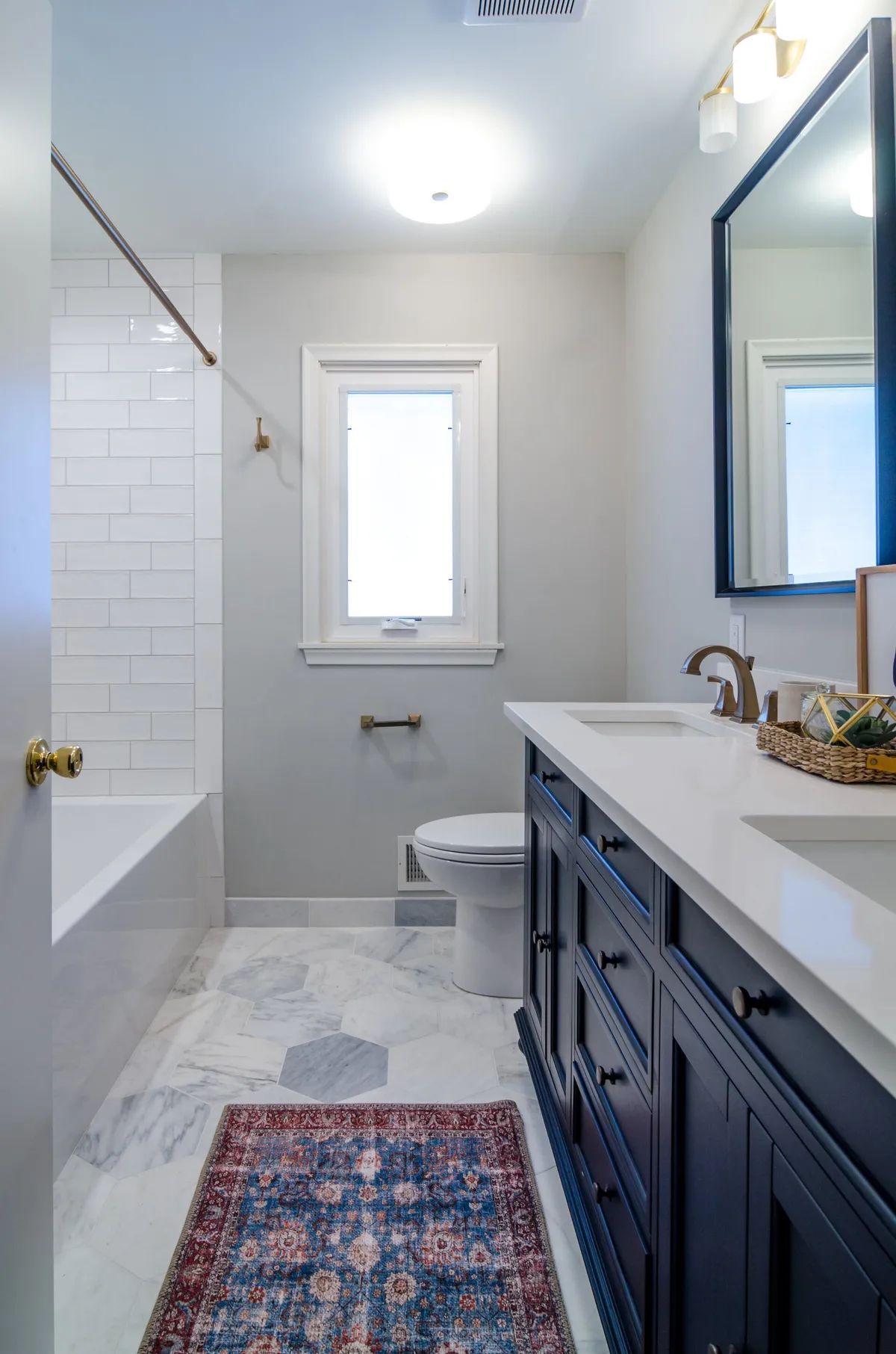 A bathroom with a sink , toilet , tub and mirror.
