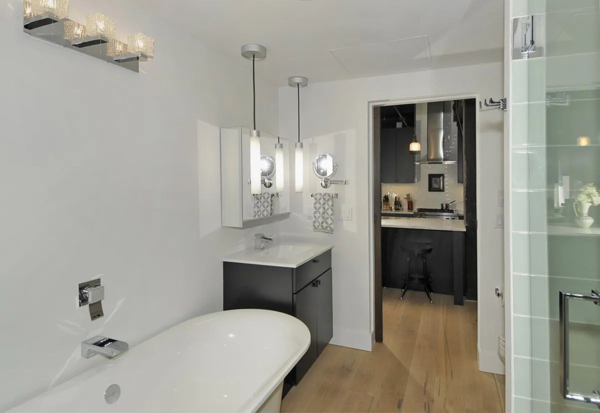 A bathroom with a tub a sink and a walk in shower