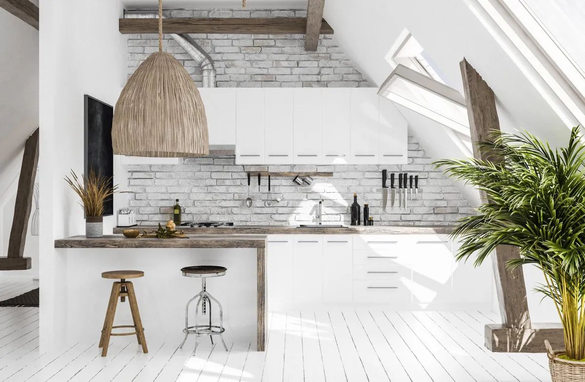 A kitchen with white cabinets , a wooden counter top , a stool and a plant.