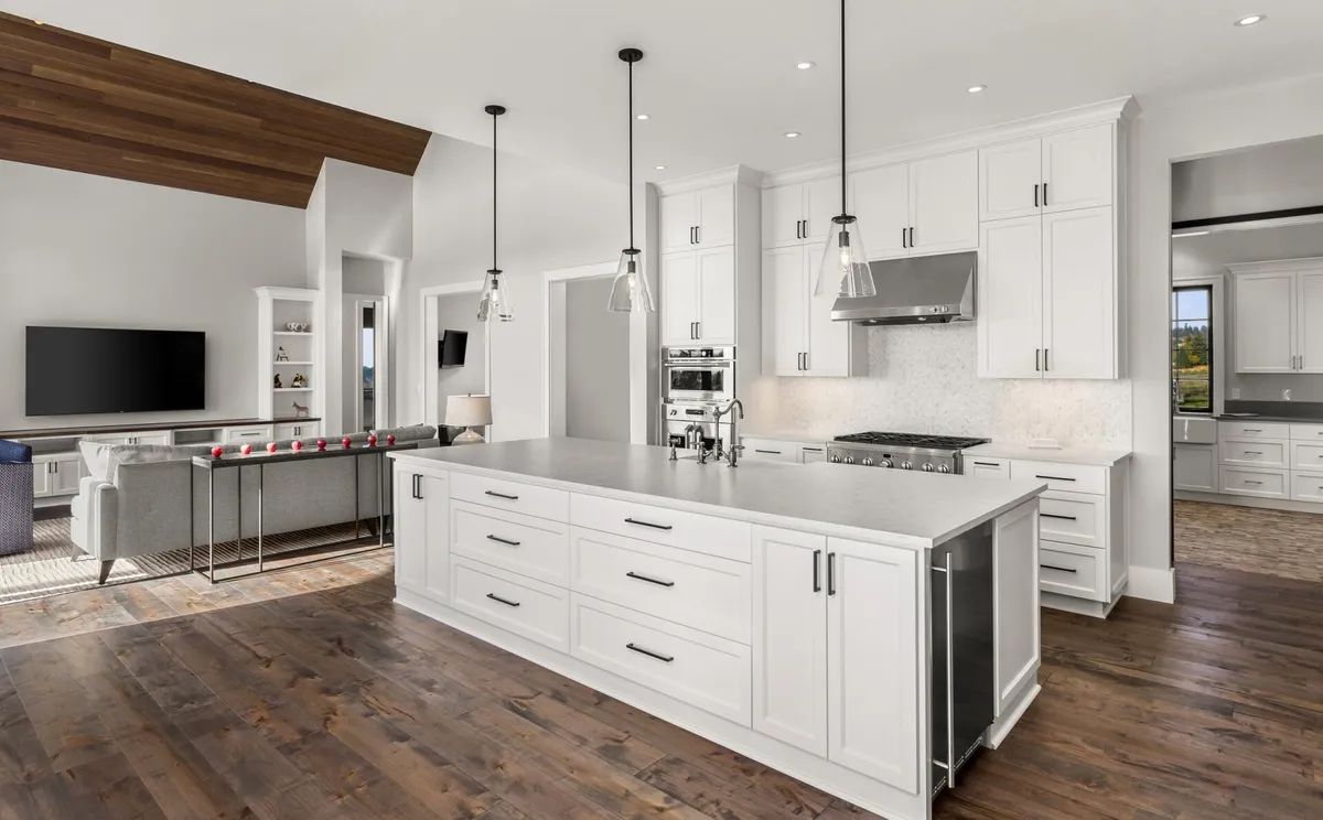 A kitchen with white cabinets and a large island in the middle of the room.
