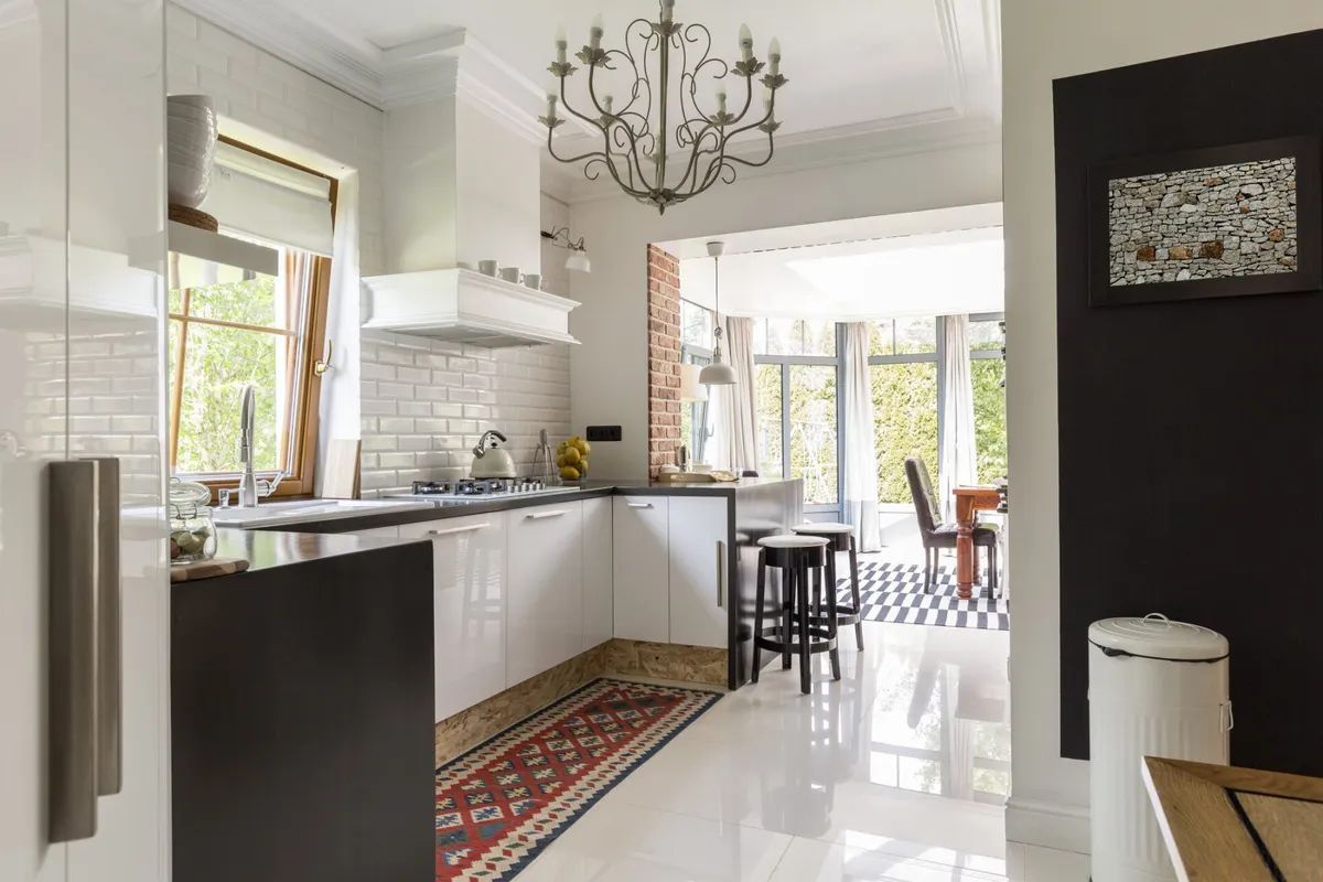 A kitchen with white cabinets and a chandelier hanging from the ceiling.
