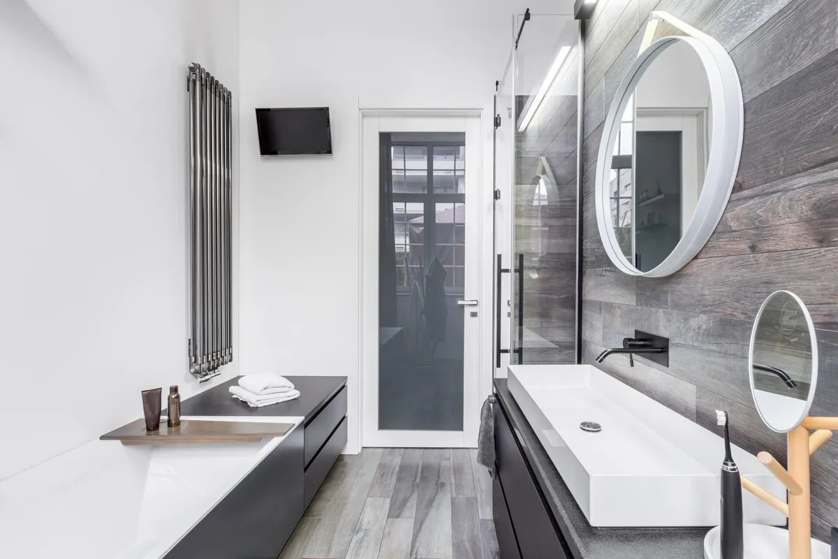 A bathroom with a sink , mirror and bathtub.