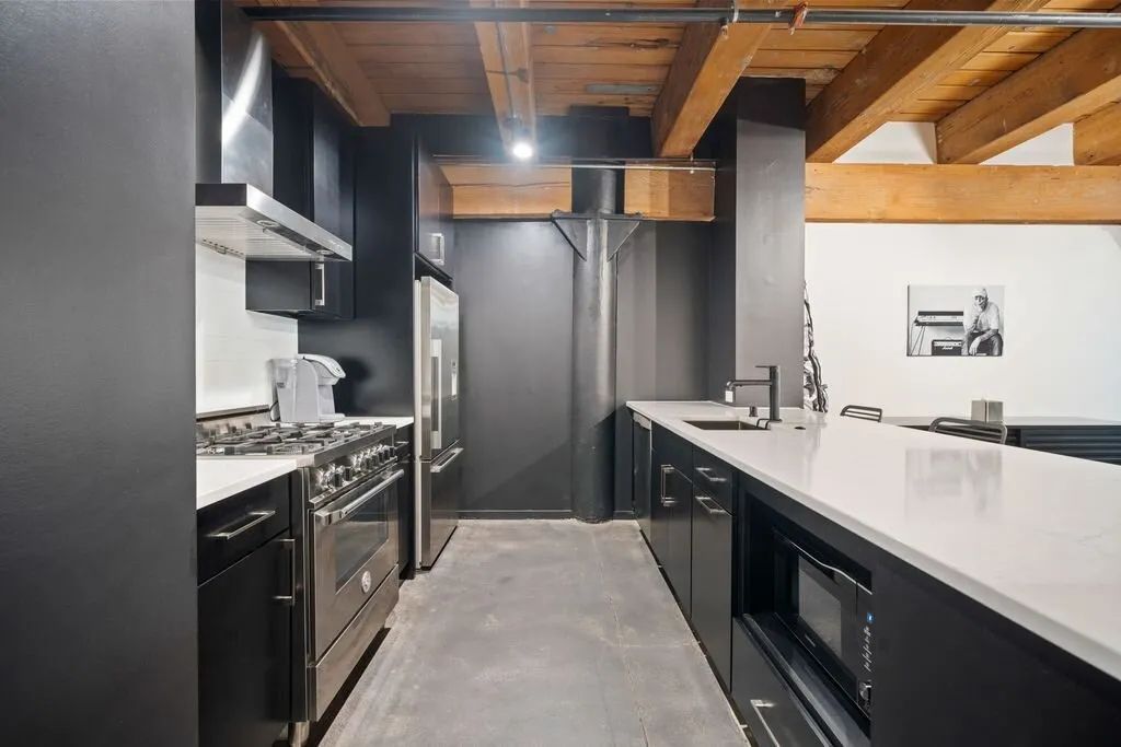 A kitchen with black cabinets and stainless steel appliances