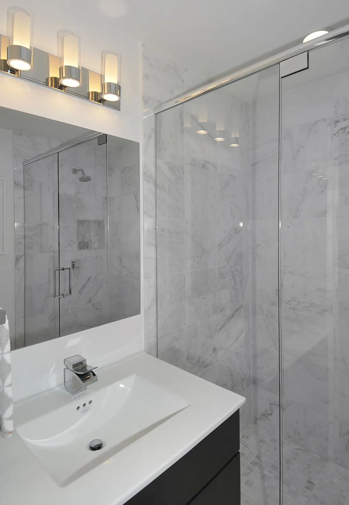 A bathroom with a sink a mirror and a shower