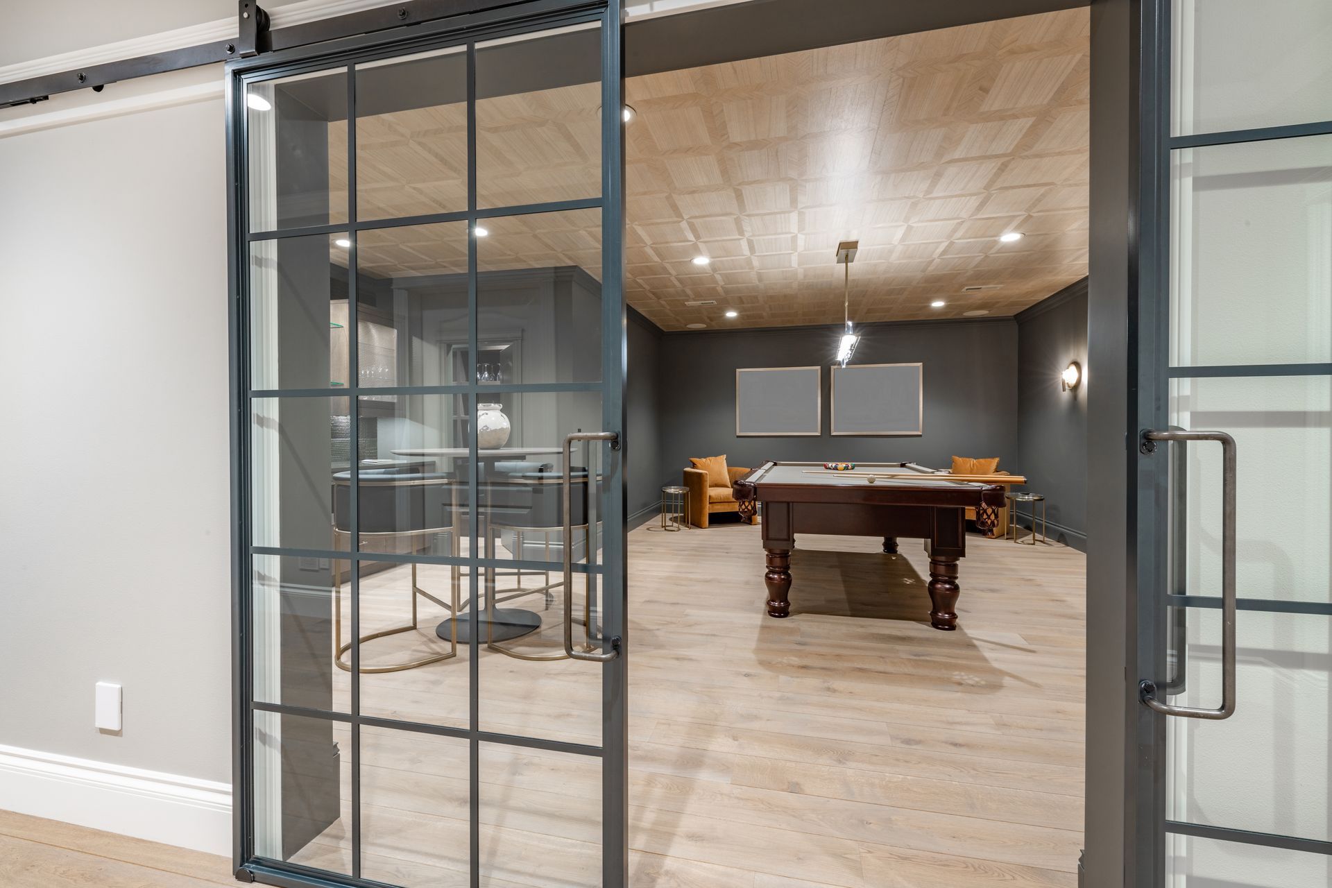 A game room with a pool table and sliding glass doors.