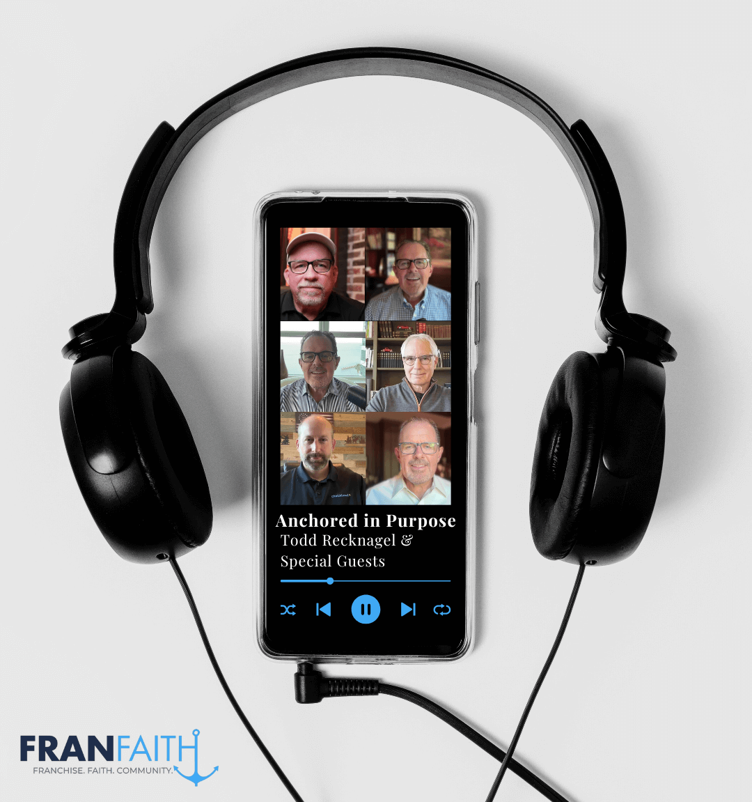 Headphones framing a phone displaying a podcast with 6 men. 