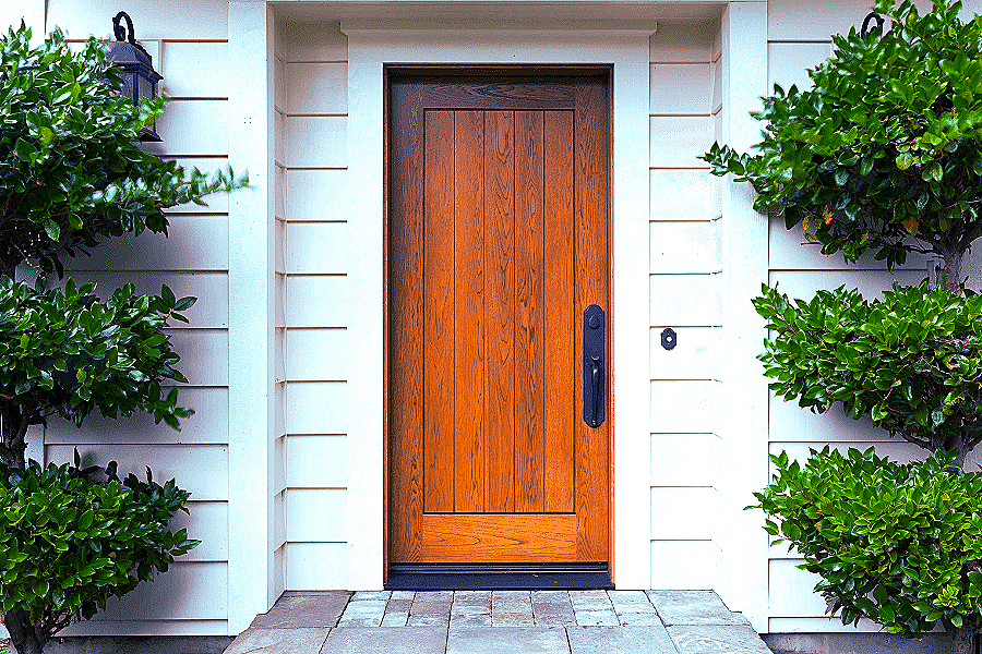 solid wood front door with black hardware and white trim 