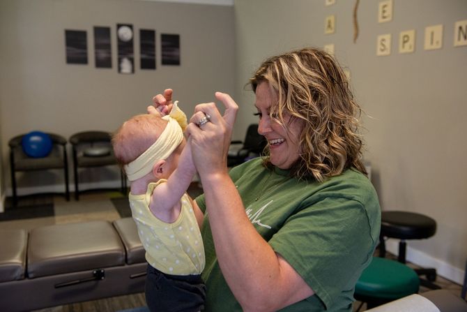 Dr. Jill holding a baby for an adjustment