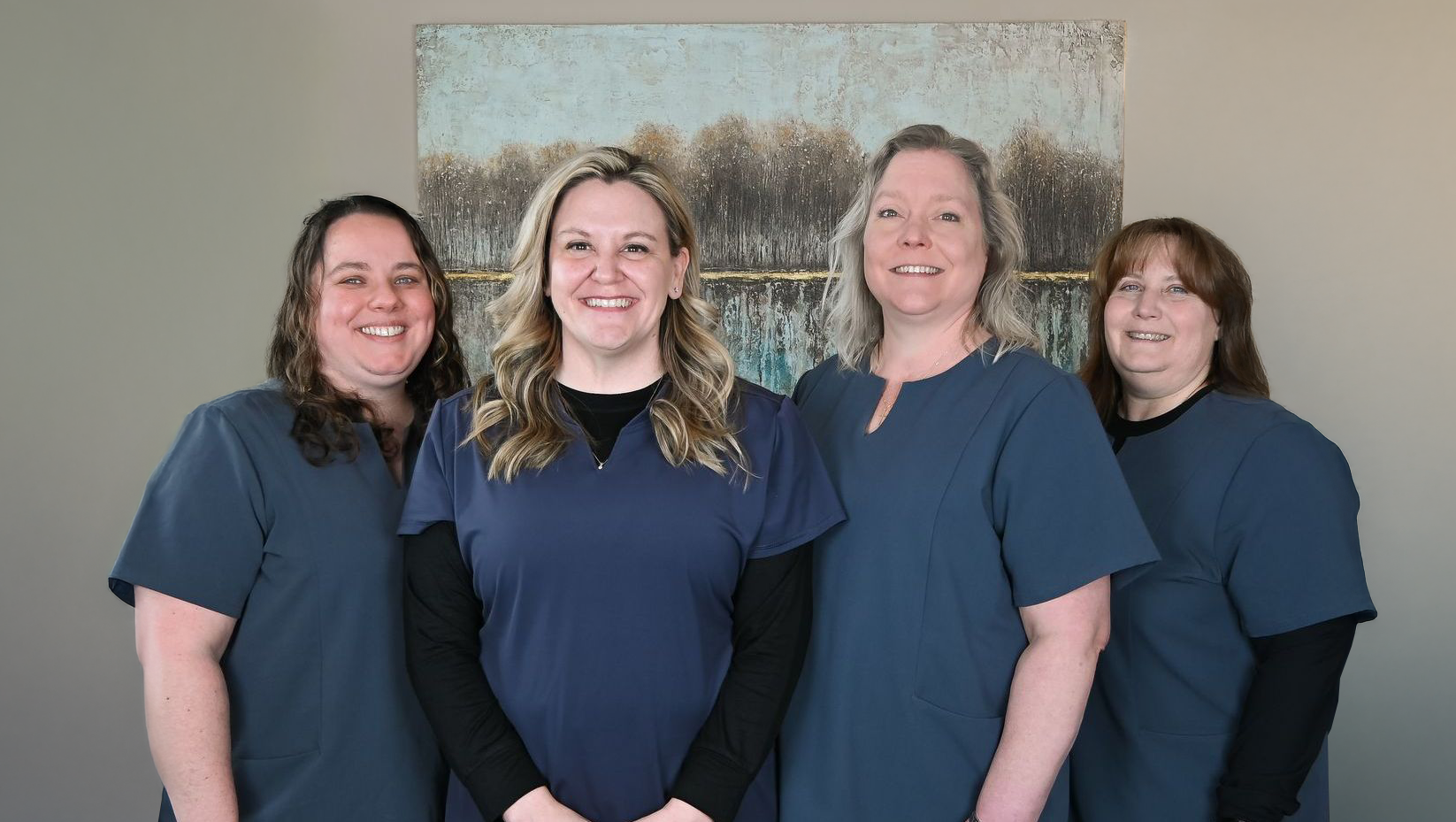 A group of women in scrubs are posing for a picture.