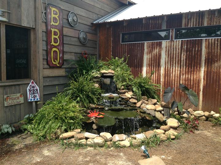 Outdoor pond decoration with BBQ sign in the background