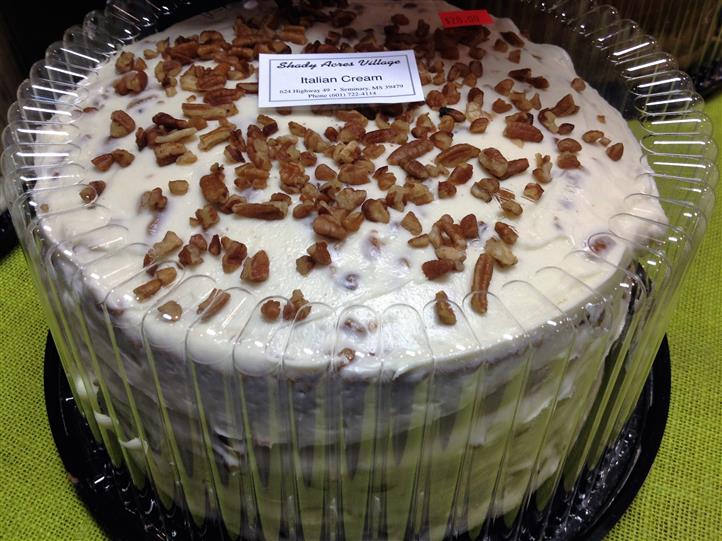 Italian Cream cake in plastic casing with toppings on it