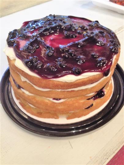 Layered cake with icing and black berry jam topping