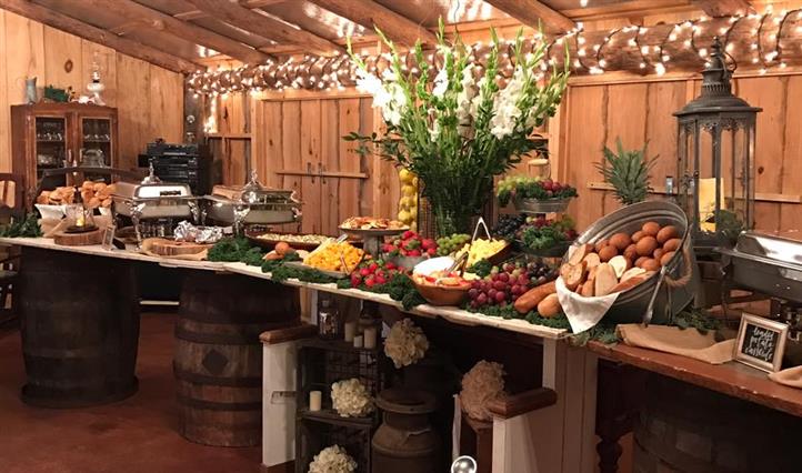 Assortment of fruits and breads on a display with a flower assortment.