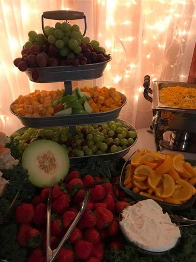 Assortment of a plethora of fruits on a table with a arranged display with a light decoration with curtains