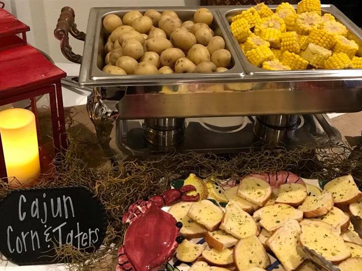 Potatoes with corn on the cob in a stove along with bread