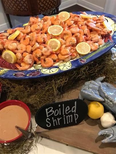 Boiled Shrimp on a platter on a display with lemon slices.