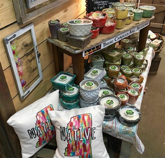 Throw pillows and candles on a display for sale