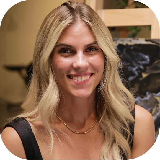 Woman with blonde hair smiling, wearing a black top and a gold necklace.