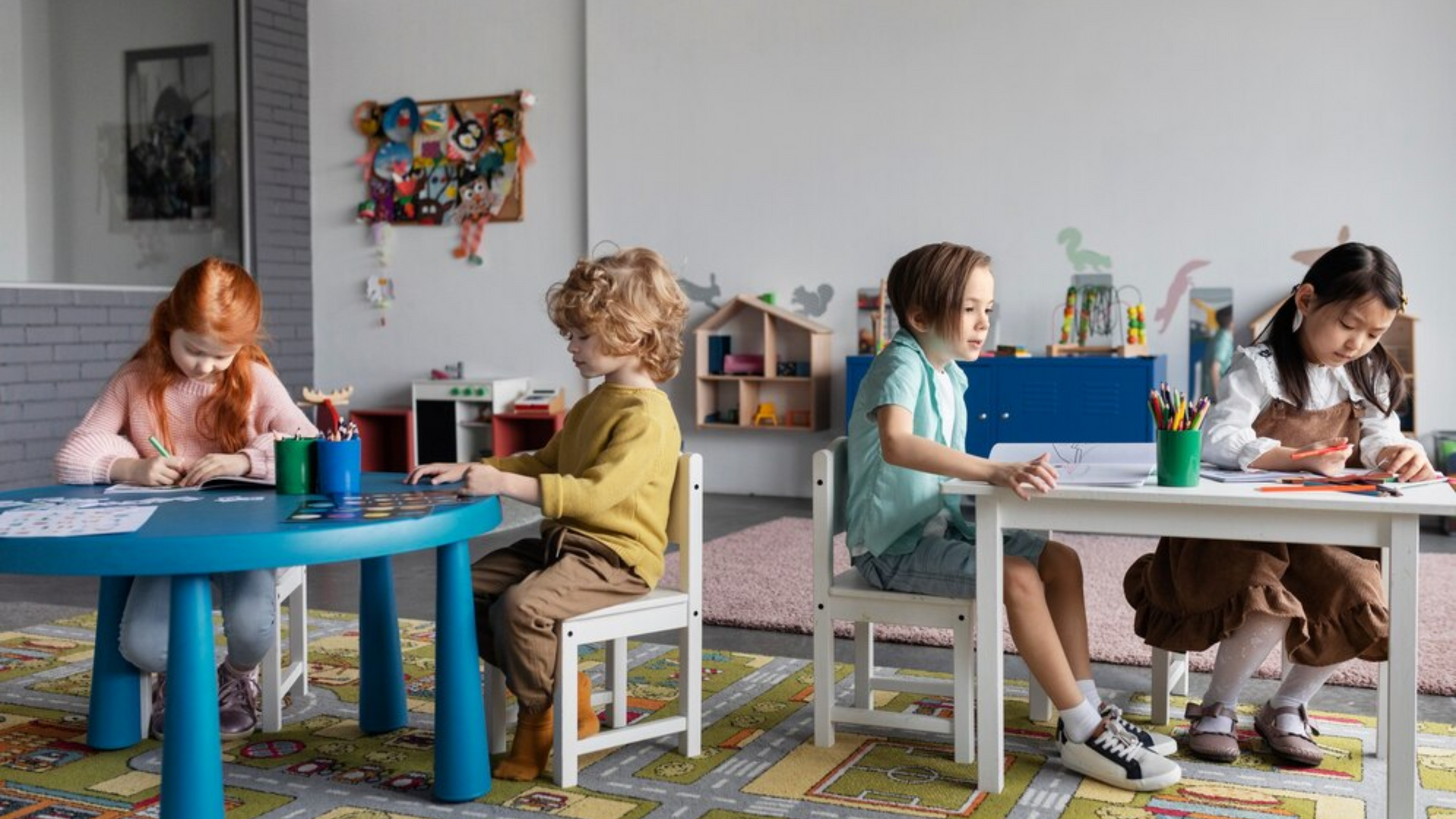 A group of children are sitting at tables in a classroom.