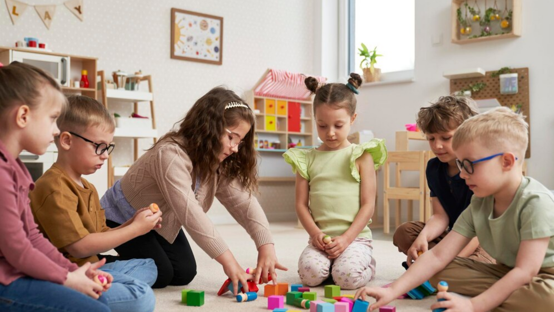 A group of children are sitting on the floor playing with blocks.