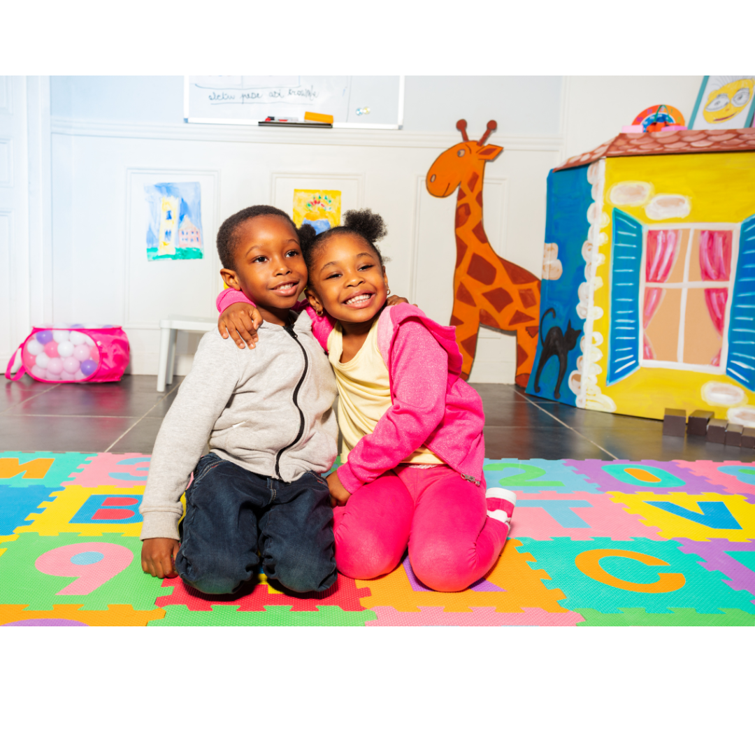 A boy and a girl are kneeling on a puzzle mat.