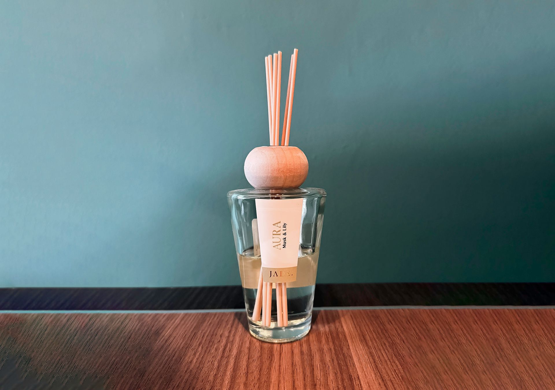 Lanterna con candela su terreno innevato in un cimitero, con una lapide scura visibile sullo sfondo.