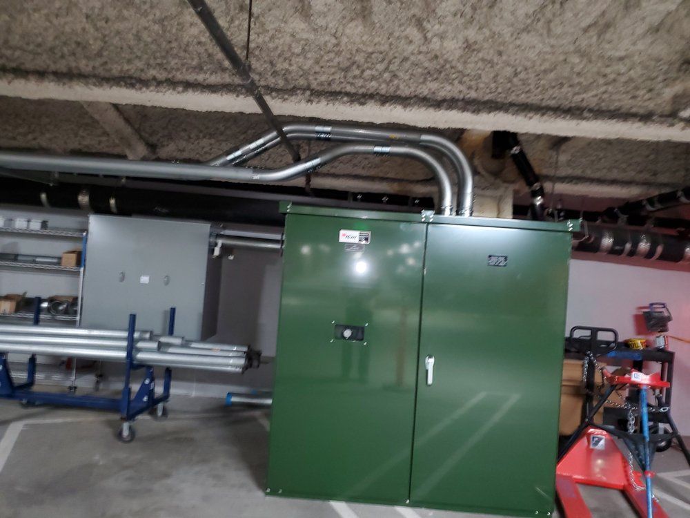 A green cabinet in a room with pipes coming out of it