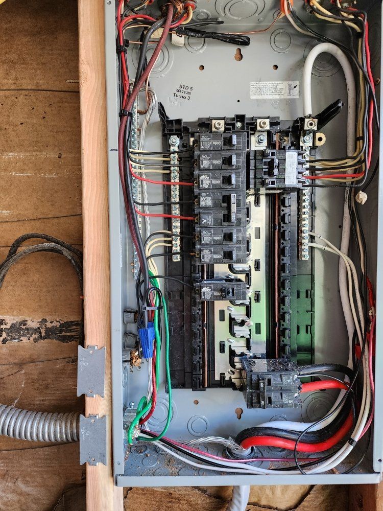 A close up of a electrical box with a lot of wires coming out of it.