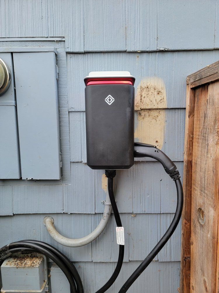 A tesla charging station is attached to the side of a building.